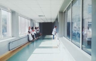 Woman in white shirt standing near glass window inside room